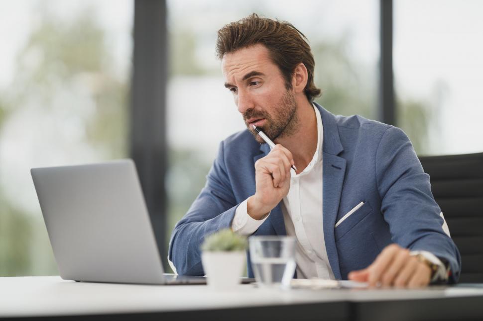 Free Stock Photo of Focused businessman working on laptop